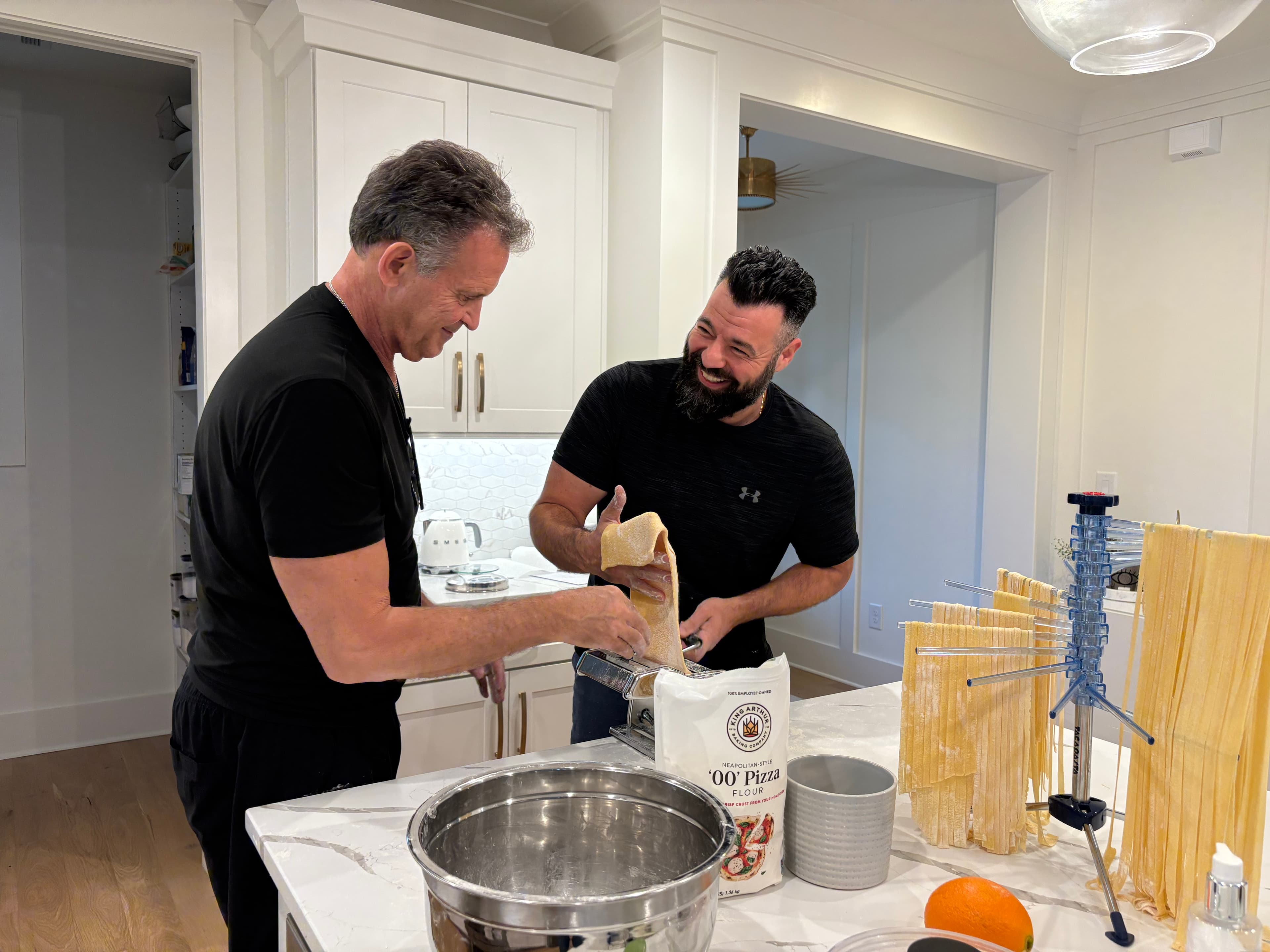 Family laughing while rolling pasta dough together